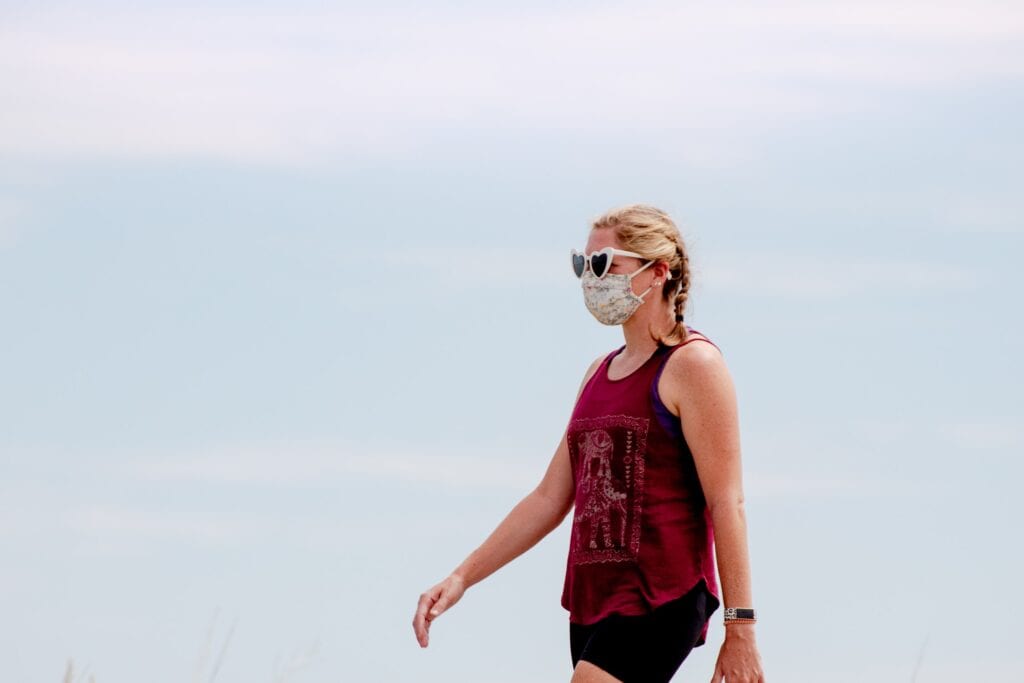 Woman walking and wearing a mask.