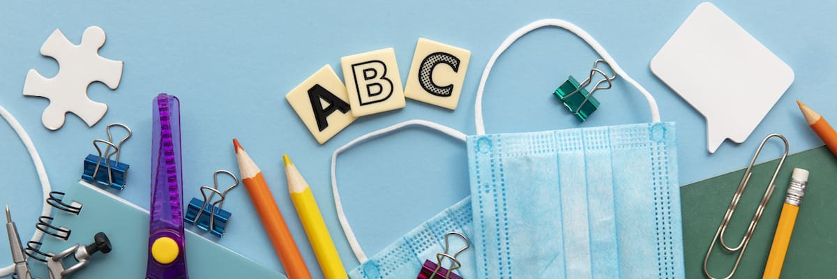 Back to school concept. School supplies with a medical face mask