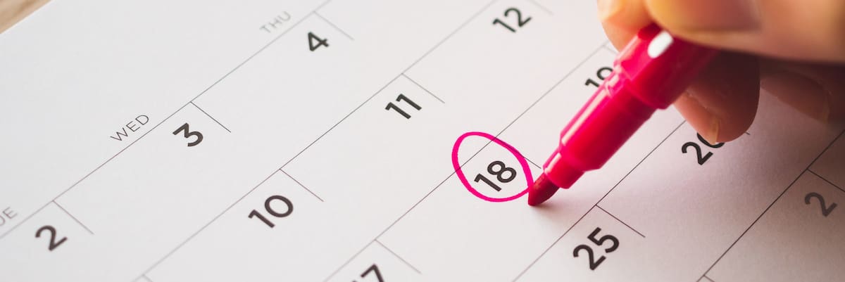 Female Hand with pen mark on calendar date