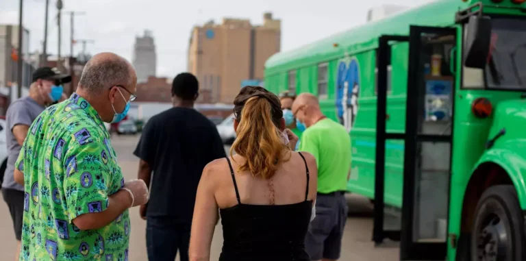 Patients line up for treatment next to Beyond the Boulevard's medical bus.