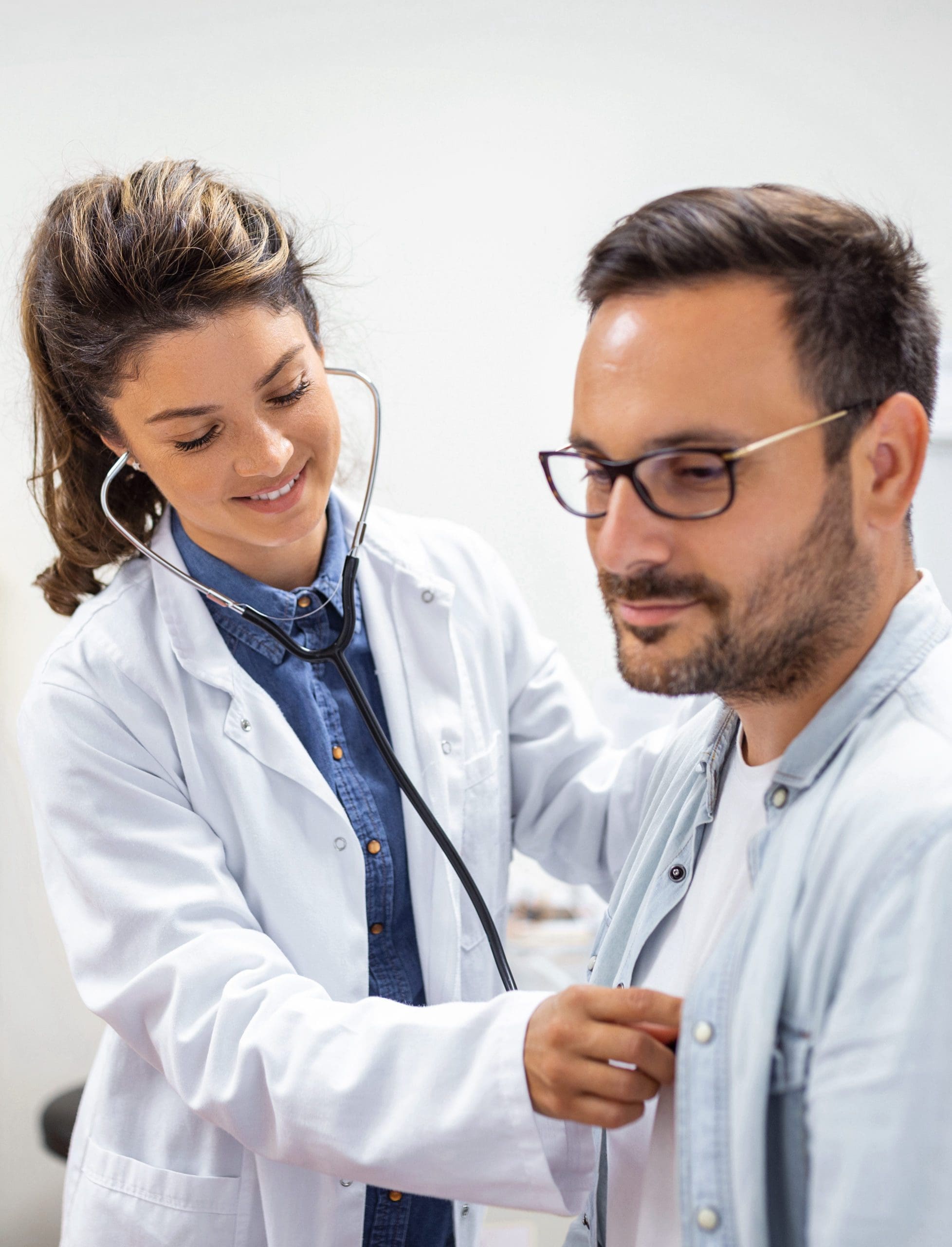 Young doctor is using a stethoscope listen to the heartbeat of the patient. Shot of a female doctor giving a male patient a check up