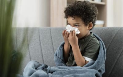 Image of a sick boy blowing his nose.